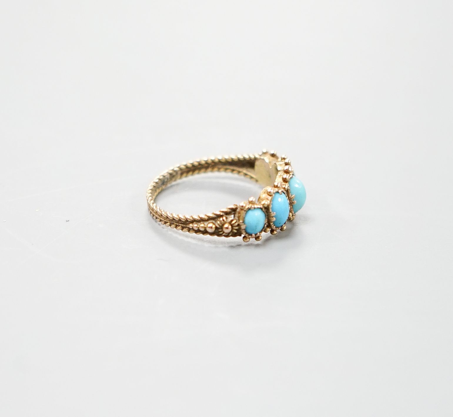 An early 19th century yellow metal and graduated five stone cabochon turquoise half hoop ring, size N, gross weight 1.9 grams.